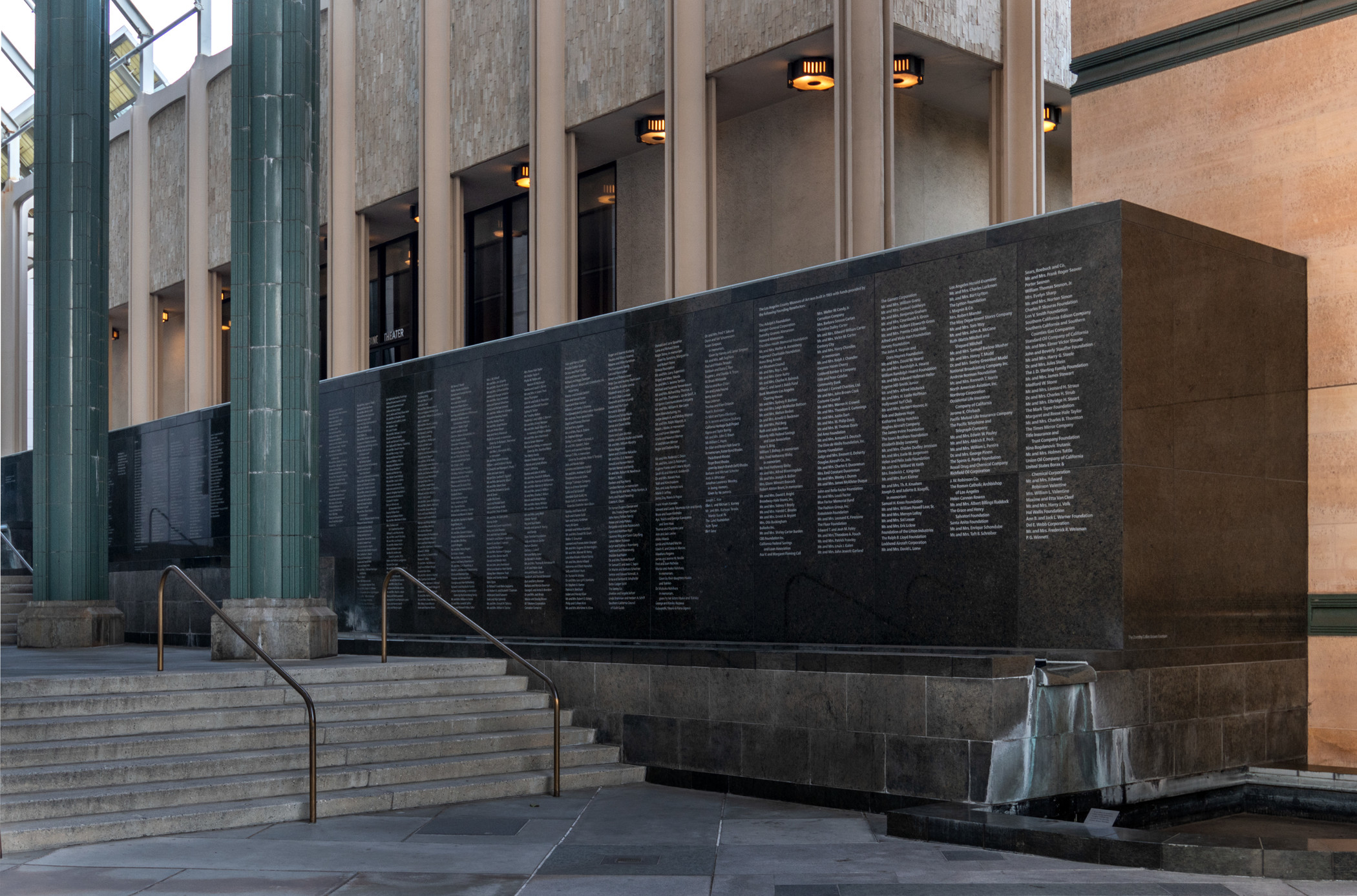 Stairs lead to a memorial wall displaying numerous engraved names.