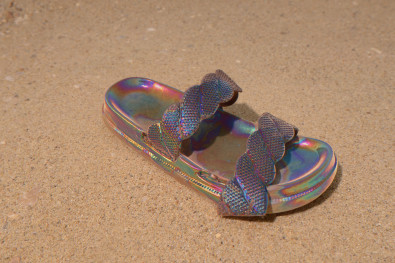 This is an image of a hyper fluorescent sandal in a seemingly open desert landscape 