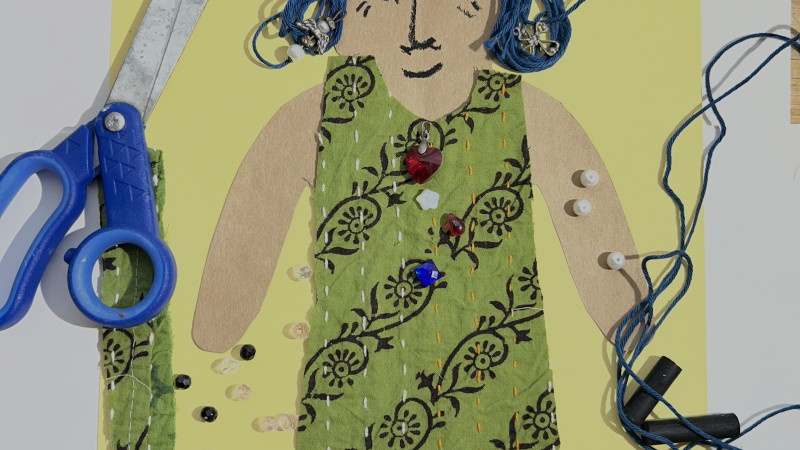Art and craft of paper doll in a fabric dress with year hair, adorned with beads