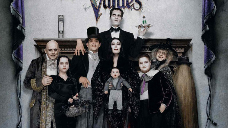 The movie poster for Addams Family Values, featuring a group portrait of the Addams family in front of a fireplace 