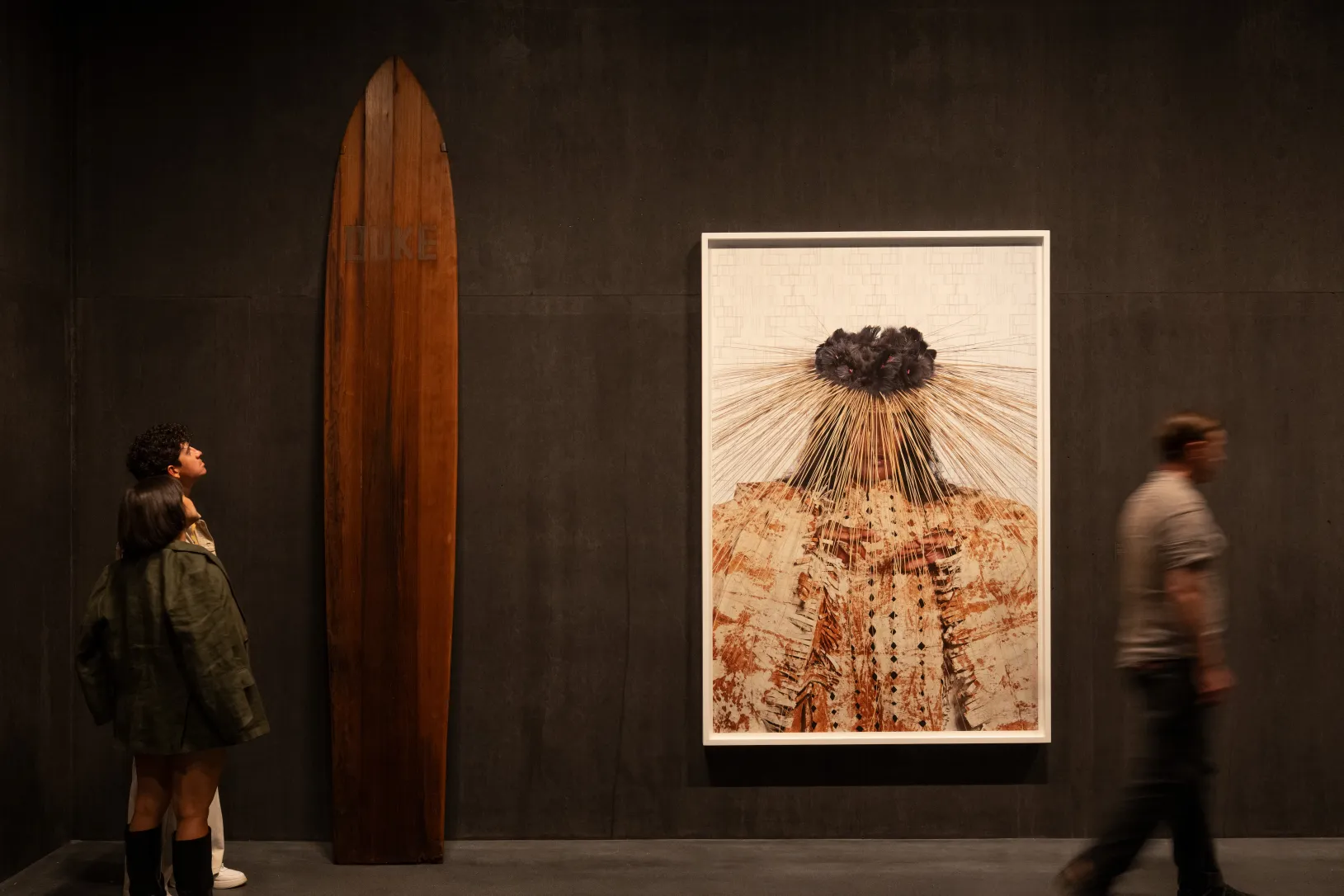 <p>Visitors in the David Geffen Galleries with Duke Kahanamoku's Surfboard, 1920s, and Lisa Reihana's Dancing Bride, 2016, Los Angeles County Museum of Art, © Lisa Reihana, photo © Museum Associates/LACMA, by Charlie Powers</p>