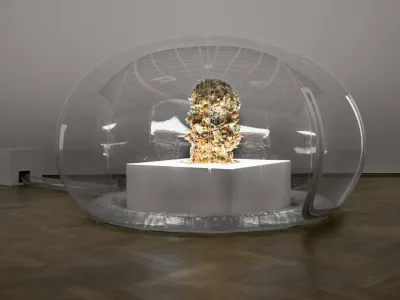 Inflatable transparent dome enclosing a white pedestal topped with a textured organic sculpture resembling clustered plant matter, illuminated from within.