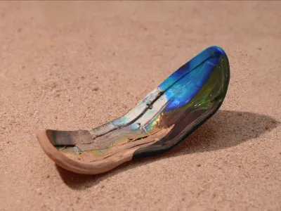 Fragment of a shoe with iridescent blue and gold patina resting on reddish desert sand, showing weathered layers and surface cracking.